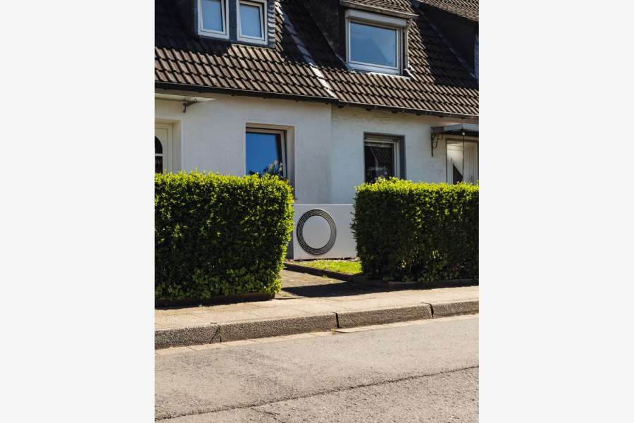 Neue Technologien sichbar integriert: Eine Wärmepumpe im Vorgarten zeigt die Energietransformation im Wohnungsbestand. Bild: Robert Poorten