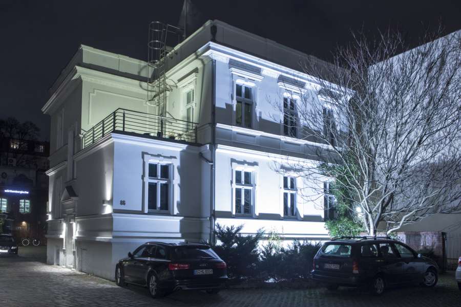 Lichtoptische Effekte entstehen bei der Außenbeleuchtung eines Hauses durch Bodeneinbaustrahler. Foto: Wüstenrot Bausparkasse AG