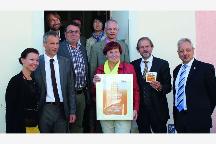 An der Übergabe der Urkunde nahmen teil (v.l.n.r.): Jana Schimke MdB (CDU/CSU-Bundestagsfraktion), Gerald Lehmann (Bürgermeister), Mathias Koch (Untere Denkmalschutzbehörde, oben), Stefan Ludwig MdL (Die Linke, verdeckt), Gerhard Lungwitz (Architekt), Kathrin Mölneck und Dr. Wolfgang Schönfelder (beide BBU), Bärbel Kohlstock (WOBAU Luckau, vorne Mitte), Jürgen Schweinberger (MIL) und Carl-Heinz Klinkmüller (Landrat Dahme-Spreewald). Foto: BBU