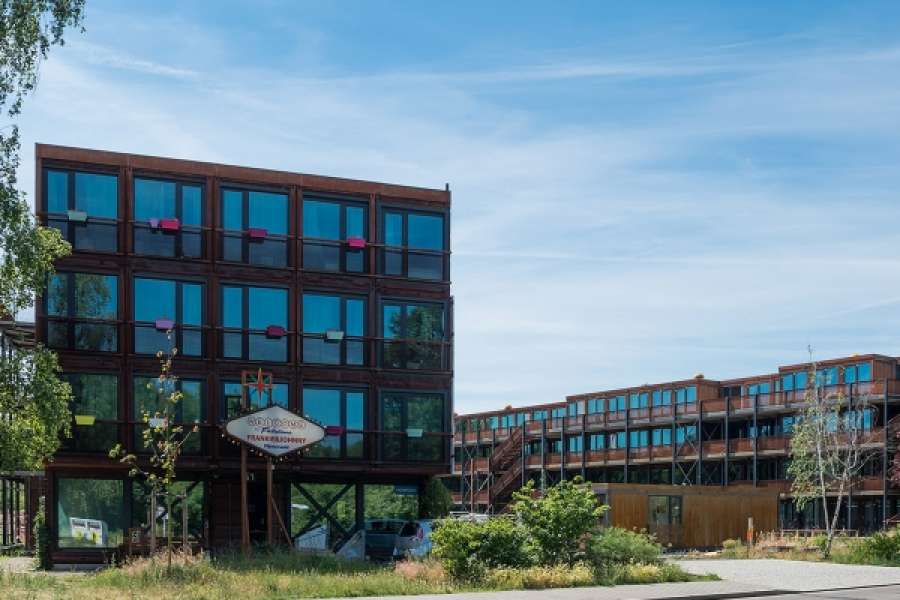 Ein dreistöckiges Haus aus Containern. Ein Mini-Apartement besitzt 25 Quadratmeter und ist komplett möbliert. BILD: HOWOGE/SUESS