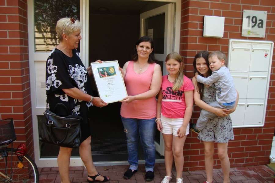 Sahle Wohnen-Kundenbetreuerin Iwonn Passehl (l.) übergab am 24.6. die Gewinnurkunde an Janine Stöhr (2.v.l.) und ihre Kinder in Hamburg.