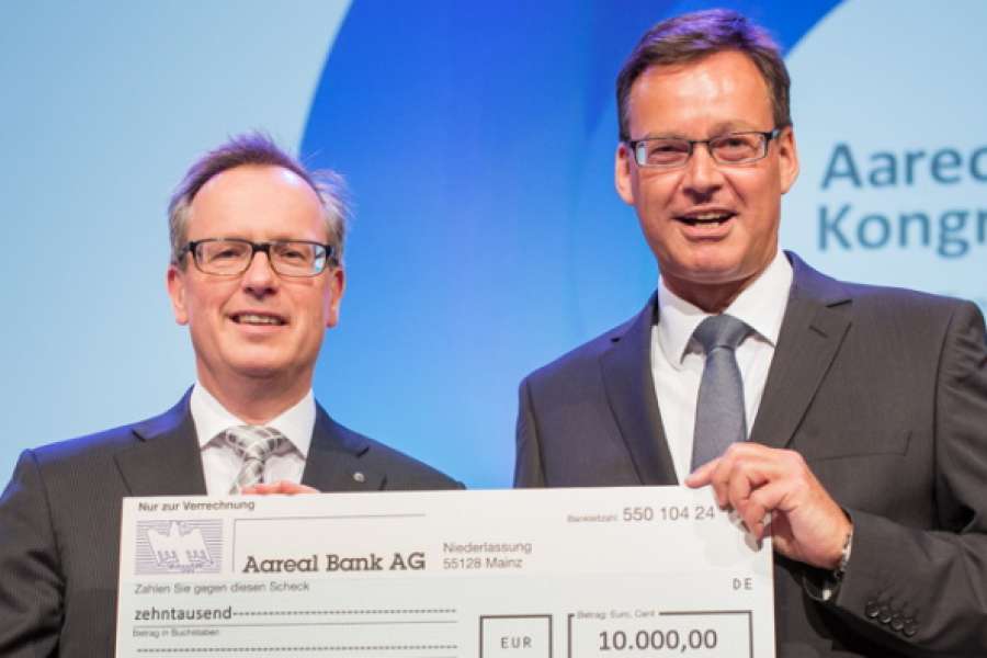 Dr. Manfred Alflen (l.) übergibt den Spendenscheck an Axel Gedaschko. Foto: Aareon